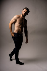 Fototapeta premium Closed up man pulling a comb on his back pocket. New jeans. Fit and handsome man. Putting something in his back pocket.