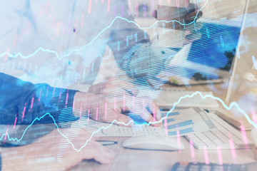 Multi exposure of chart with man typing on computer in office on background. Concept of hard work.