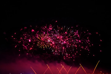 bright red flashes of fireworks in the black sky