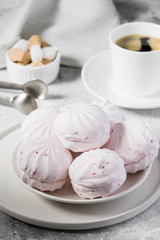 Pink marshmallows with blackcurrants on a plate. Light grey background