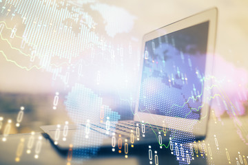 Stock market graph on background with desk and personal computer. Double exposure. Concept of financial analysis.