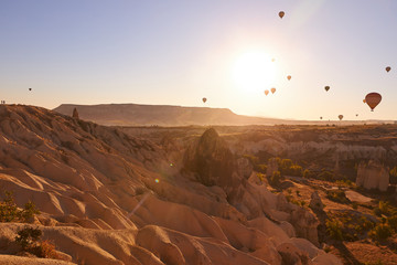 morning photo in Cappadocia with air balloons in the blue sky over sandy hills