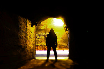 Fototapeta premium A man standing in an underground corridor. Man in tunnel