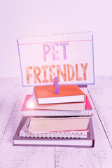 Text sign showing Pet Friendly. Business photo text used to describe a place that is suitable or allowed for pets pile stacked books notebook pin clothespin colored reminder white wooden