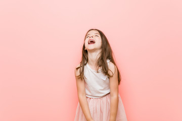 Little girl wearing a princess look relaxed and happy laughing, neck stretched showing teeth. © Asier