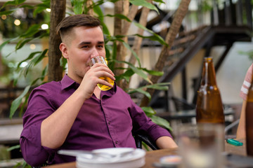 Man sitting outdoors and drinking beer from glass