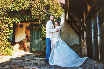 Beautiful and happy young couple man and woman in a beautiful garden in the yard of a country house