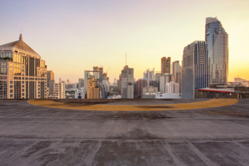 The cement floor with blurred of cityscape background in the evening at Bangkok , Thailand. Cement floor on the roof with sunset over the building in capital.