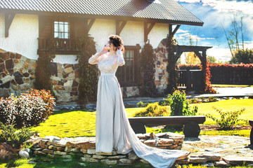 Young adult beautiful happy woman in a beautiful dress on the background of a beautiful house in the garden