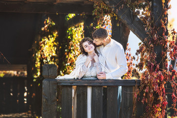 Beautiful and happy young couple man and woman in a beautiful garden in the yard of a country house