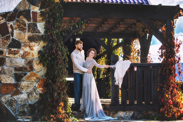 Beautiful and happy young couple man and woman in a beautiful garden in the yard of a country house