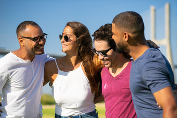 Happy carefree close friends hugging each other. Young men and woman standing outside, embracing, chatting, laughing. Old friends meeting concept