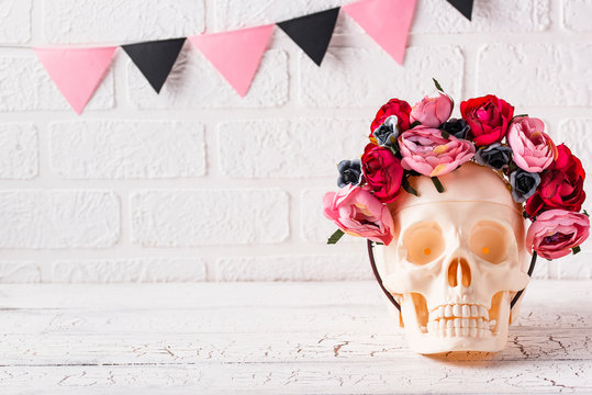 Skull with wreath of pink flowers