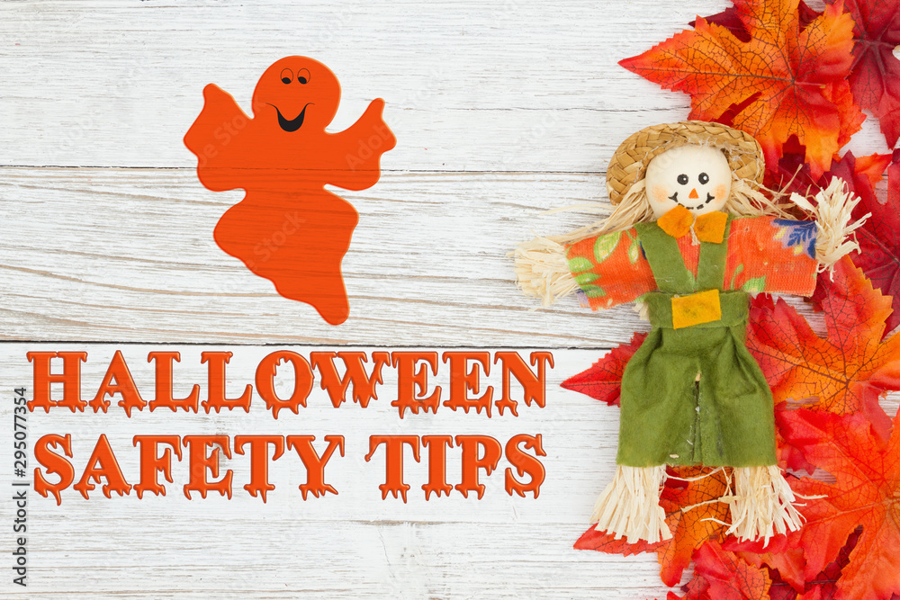 Wall mural Halloween safety tips message with red and orange fall leaves with a scarecrow - Wall murals