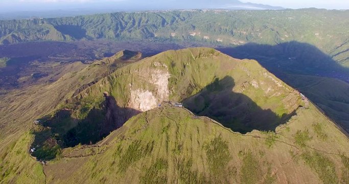 Forward moving drone footage over magnificent and beautiful volcanic mountains of Batur,Indonesia showing the deep depressions and vast barren land.