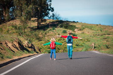 Obraz premium Happy boy and girl enjoy travel on road in mountains