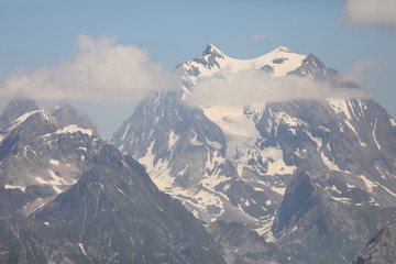 Snowy mountains with clouds and blue sky