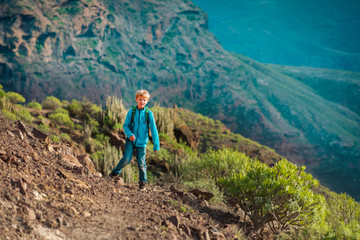 Naklejka na ściany i meble young boy hiking in mountains, family travel