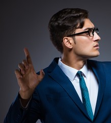 Businessman pressing virtual buttons on gray background