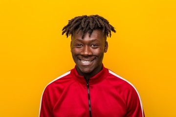 Close up of a young african sporty man standing against a yellow background
