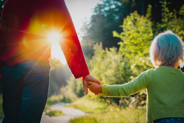 Fototapeta na wymiar boy and little girl holding hands in sunset nature