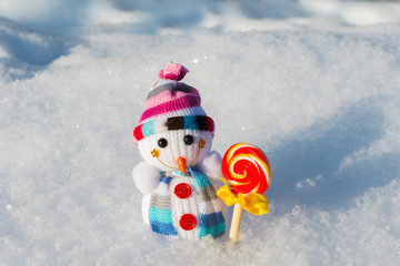 Obraz premium small knitted snowman with candy in the snow