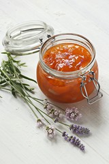Apricot lavender marmalade in a glass jar on a rustic wooden table