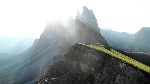 Alpine mountain peaks with hiker watching sunrise