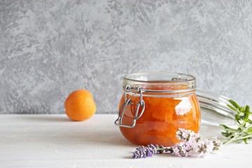Apricot lavender marmalade in a glass jar on a rustic wooden table