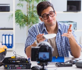 Vlogger recording computer repair on camera for vlog blog