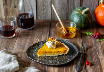 Pumpkin pie on a wooden background. Traditional recipe.