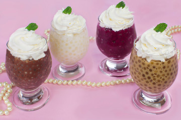 Brazilian dessert made of tapioca pearls called sagu in many flavors in a basket in pink background