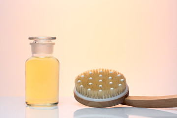 A bottle of cosmetic and massage brush on beautiful background 
