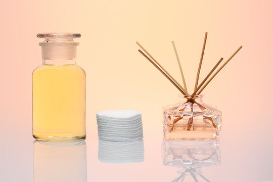 A bottle of cosmetic, cotton pads and aroma diffuser on beautiful backgroun