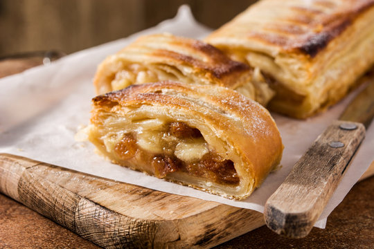 Traditional homemade apple strudel on brown background