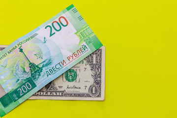 Obraz premium 1 dollar and 200 rubles on yellow background. Place for text.