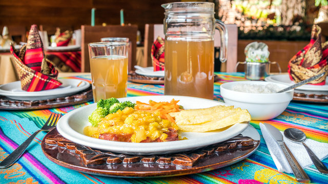 Delicious beef with mango sauce, served with fries and vegetables. Brown traditional amazonian drink.