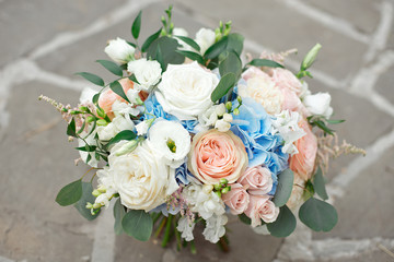 Gorgeous bouquet of roses, hydrangeas, ozotamnusa,eucalyptus on a beautiful concrete path