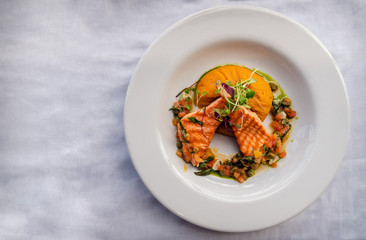 Grilled trout fish with mashed sweet potato and orange sauce. White background. Top view