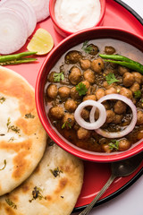Pindi Chole Kulche or roadside choley Kulcha popular in India and pakistan is a popular streetfood. It's a spicy Chickpea or chana curry served with Indian Flat Bread. selective focus