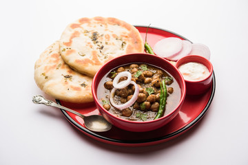 Pindi Chole Kulche or roadside choley Kulcha popular in India and pakistan is a popular streetfood. It's a spicy Chickpea or chana curry served with Indian Flat Bread. selective focus