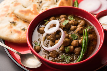 Pindi Chole Kulche or roadside choley Kulcha popular in India and pakistan is a popular streetfood. It's a spicy Chickpea or chana curry served with Indian Flat Bread. selective focus