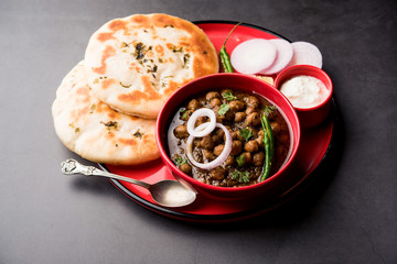 Pindi Chole Kulche or roadside choley Kulcha popular in India and pakistan is a popular streetfood. It's a spicy Chickpea or chana curry served with Indian Flat Bread. selective focus