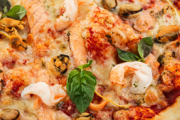 Seafood Italian pizza with shrimp,squid, mussels, fresh herbs and mozzarella on a crusty base viewed from above on Gray background. Horizontal photo.
