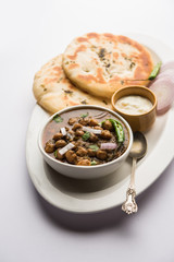 Pindi Chole Kulche or roadside choley Kulcha popular in India and pakistan is a popular streetfood. It's a spicy Chickpea or chana curry served with Indian Flat Bread. selective focus
