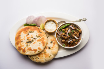 Pindi Chole Kulche or roadside choley Kulcha popular in India and pakistan is a popular streetfood. It's a spicy Chickpea or chana curry served with Indian Flat Bread. selective focus