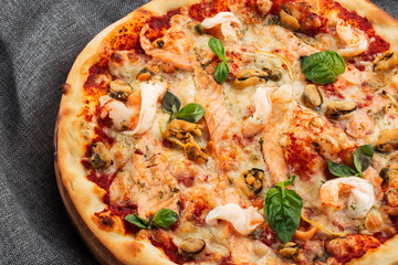 Seafood Italian pizza with shrimp,squid, mussels, fresh herbs and mozzarella on a crusty base viewed from above on Gray background. Horizontal photo.