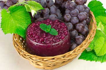 Brazilian dessert made of tapioca pearls called sagu in red wine flavor in a basket with grapes