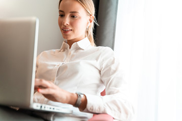 Business woman sit indoors in cafe using laptop computer.