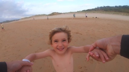 4K footage of Close up of happy cute child having fun spinning with his father on summer vacation in Dad and son bonding, happy family moments together concept. Motion video with beach background. - Powered by Adobe